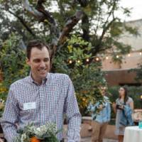 Three alumni talking at table